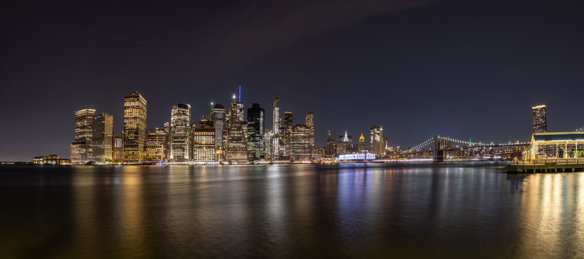 Manhattan skyline reflected in the East River at night